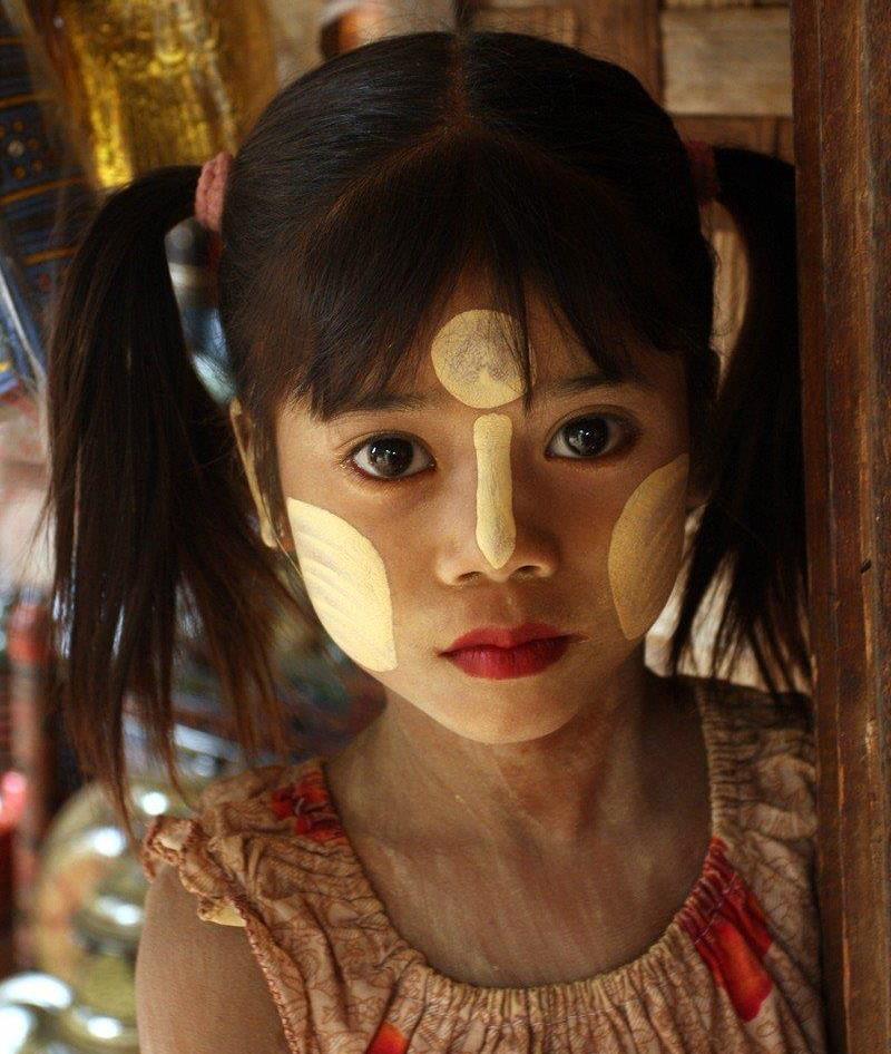 a girl with white Thanakha powder on her cheeks