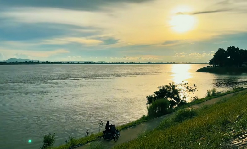 Walking near temples and riverside paths in Pakse at sunset.